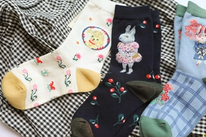 Detail of three pairs of cotton socks featuring animal embroidery and floral patterns