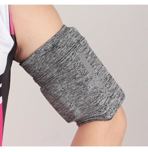 Close-up of gray sports arm band with reflective pattern worn on model's arm for running
