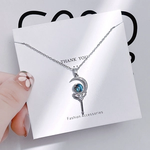 Close-up of crescent moon staff pendant with blue galaxy stone and zircon inlay