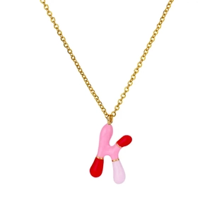 Dettaglio della collana d'oro con un ciondolo colorato a lettera K in smalto rosa e rosso