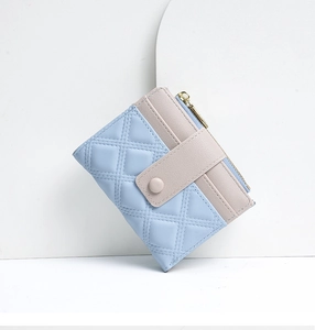 Close-up of blue and beige quilted short wallet for women with snap button and zipper
