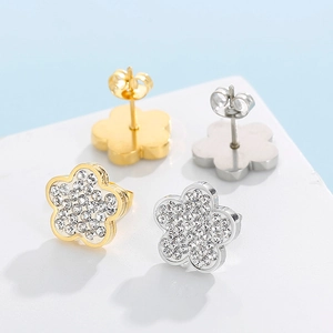 Detailed close-up of sparkling flower stud earrings in gold and silver steel finish