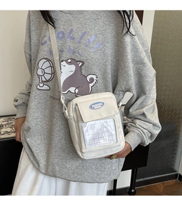 Mannequin portant un petit sac bandoulière en toile avec fenêtre et étiquette bleue