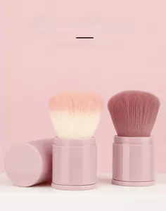 Detail of retractable makeup brush with soft bristles and pink portable storage tube