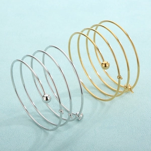 Minimalist multi-layered spiral bangle in gold and silver finish with metal beads