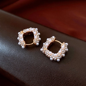 Détail de boucles d'oreilles en U plaquées or 18k avec perles et pavé de cristaux chic