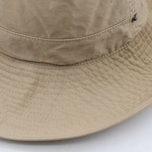 Detail of khaki sun hat featuring reinforced stitching on wide brim and metal eyelets