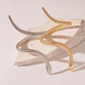 Exaggerated snake-shaped wrap arm cuffs in gold and silver with realistic scales