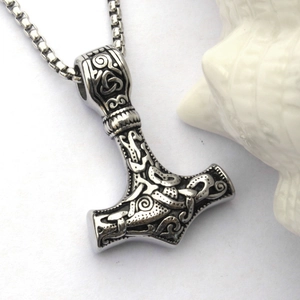Macro shot of stainless steel Mjolnir pendant with intricate Viking knot engravings