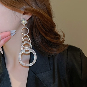 Macro view of tiered silver layered rhinestone hoop earrings on model with sparkling detail