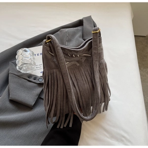 Detail of gray suede shoulder bag featuring bohemian tassels and exquisite embroidery