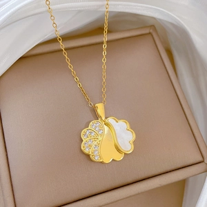 Detailed shot of golden ginkgo leaf pendant with zircons and mother of pearl inlay