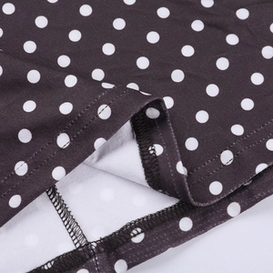 Detail shot showing high-quality double-needle stitching on black polka dot dress hem