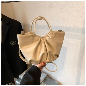 Detail of beige pleated cloud bag with soft leather texture for elegant daily commuting