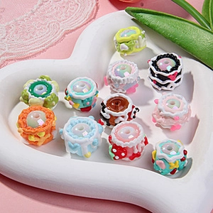 Assorted colorful resin cake and dessert beads for DIY jewelry in a heart shaped white tray