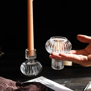 Minimalist pumpkin shaped ribbed glass candle holder with hand for scale reference