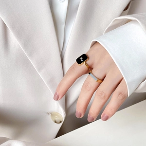 Detailed view of a gold ring with black enamel inlay and a small diamond accent