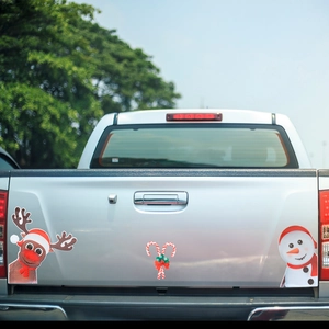 Reflective Christmas magnets with reindeer and snowman designs on silver pickup tailgate