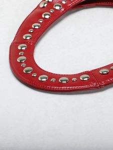 Macro detail of silver studs and stitching on red punk style leather shoulder bag