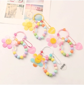 Detail of colorful beaded keychains featuring smiley flowers and heart-shaped LOVE charms