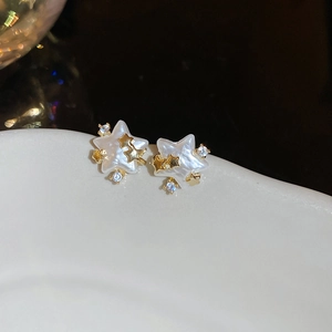 Vue macro de boucles d'oreilles étoile en or 14 carats avec nacre et zircons cubiques