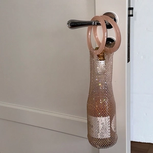 Pink rhinestone mesh wine bag with circular handles for elegant portable bottle carrying
