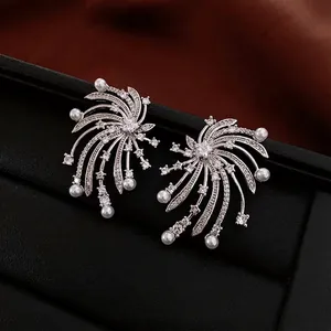 Elegant silver starburst pearl earrings with cubic zirconia on black leather display stand