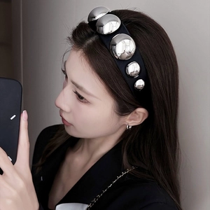 Elegant wide black headband with silver gradient metal studs shown on a female model