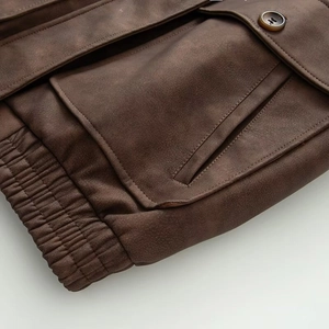 Detail of vintage brown faux leather jacket featuring cargo pockets and elastic hem design