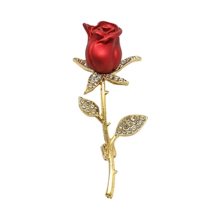 Elegant red rose brooch with gold metal stem and crystal accents on a white background