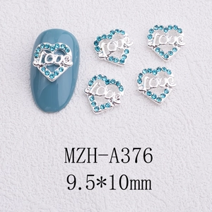 Detailed view of silver alloy heart nail charms with blue rhinestones and Love text