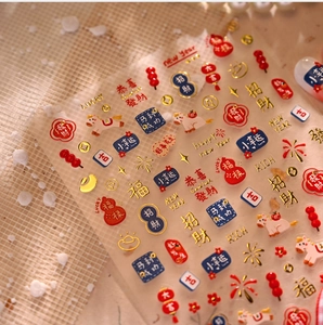 Macro detail of 3D embossed Chinese New Year nail art stickers with gold foil texture