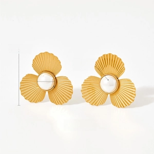 Detailansicht großer goldener Blütenohrringe mit Perlen und strukturierten Metallblättern