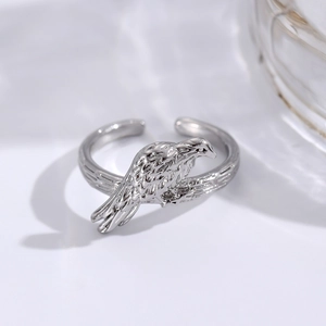 Detail of silver bird ring featuring intricate branch textures and adjustable open band