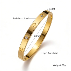 Détail d'un bracelet de 6mm en acier doré avec trèfles et pierres de zircone