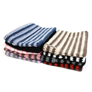 Detailed view of various striped and checkered knit beanies in multiple colors