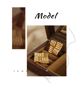 Detailed close-up of gold square earrings featuring a woven texture in a jewelry box