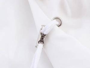 Macro shot of white drawstring and silver metal cord lock toggle on high collar jacket