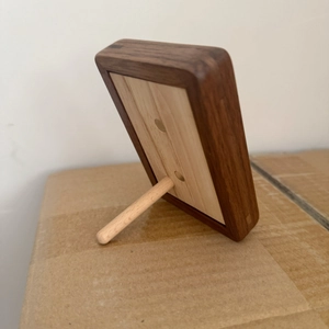 Detail view of the back of a solid walnut wood photo frame showing the support stand