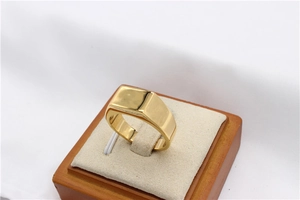 Macro view of gold rectangular signet ring with flat polished finish on display stand