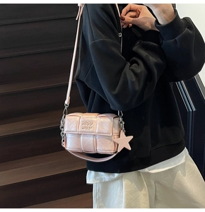 Détail du sac bandoulière carré tissé rose avec pendentif étoile et chaîne argentée