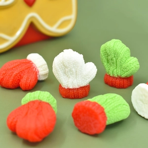 Close-up of miniature knitted gloves in red, white and green for DIY Christmas decor