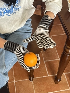 Detalle de guantes de invierno de punto con rayas blancas y negras y puños elásticos acanalados