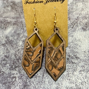 Detail of bohemian leopard print leather inlay within a geometric wooden earring frame