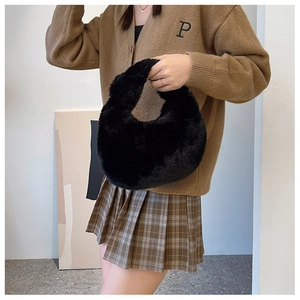 Close-up of fluffy black plush material and texture on a stylish small shoulder bag