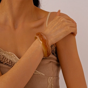 Macro detail of amber resin irregular wide bangle with vintage tortoiseshell texture