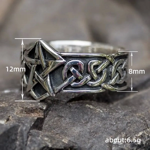 Bague vintage pentagramme en acier oxydé avec nœuds celtiques sur fond de roche