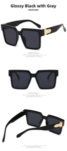 Detail view of square black sunglasses with gold M metal hinge and gray UV lenses