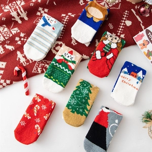 Plush Christmas coral fleece socks set with festive patterns on red knit background