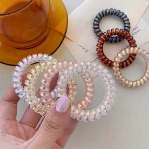 Close-up of colorful iridescent spiral hair ties in champagne gold and pearlescent white